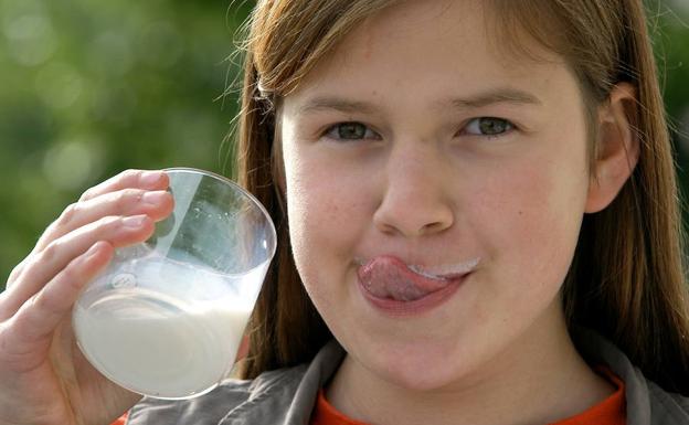 Una niña bebe leche en una granja de Dresde (Alemania)./AP