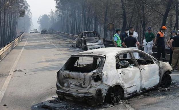 Restos de varos vehículos calcinados durante el incendio de Portugal.