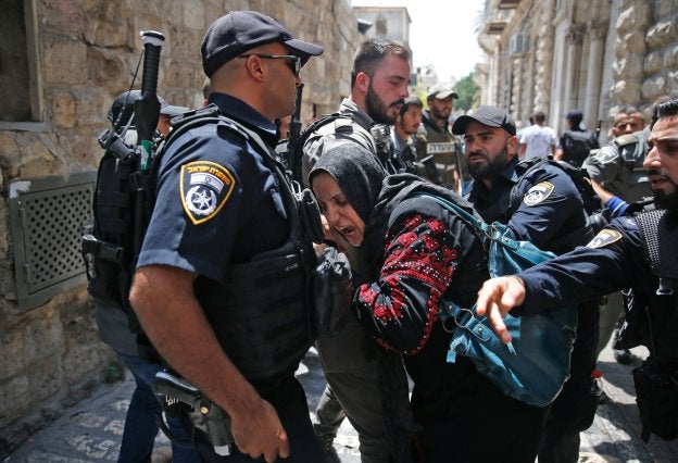 La Policía israelí impide el paso de una mujer palestina por la Puerta de los Leones. :: AHMAD GHARABLI / afp