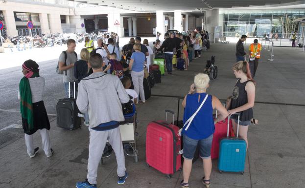 Numerosas personas hacen cola a la espera de transporte en el aeropuerto de Málaga durante la huelga de los taxis (archivo).