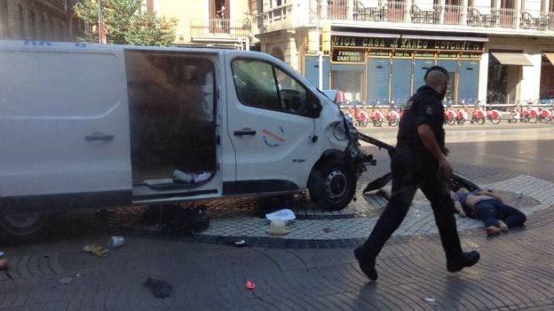 Un mosso corre hacia una de las víctimas atropellada por Younes Abouyaaqou en Las Ramblas. :: r. c.