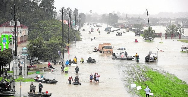 Decenas de personas caminan por una carretera después de haber sido evacuadas de sus casas en Houston. :: Joe Raedle/ afp