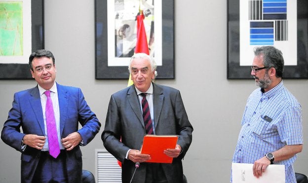 El árbitro, Marcos Peña, entrega el laudo al director de Eulen, Emilio García, y al portavoz de los trabajadores, Juan Carlos Giménez . :: efe