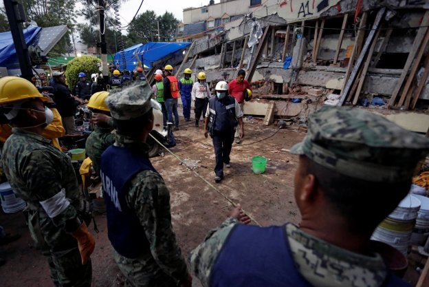 Un sanitario camina hacia los soldados durante la búsqueda de estudiantes en la escuela Enrique Rebsamen de Ciudad de México. :: reuters
/