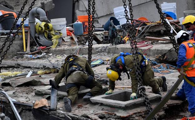 Especialistas desplegados en el número 286 de la calle Álvaro Obregón trabajan en lo que queda del edificio en el que estaba la oficina del malagueño. /AFP