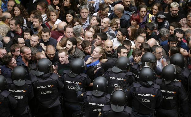 Antidisturbios de la Policía Nacional forman ayer un cordón de seguridad en los alrededores del colegio Ramón Llull de Barcelona./Alberto Estévez (Efe)
