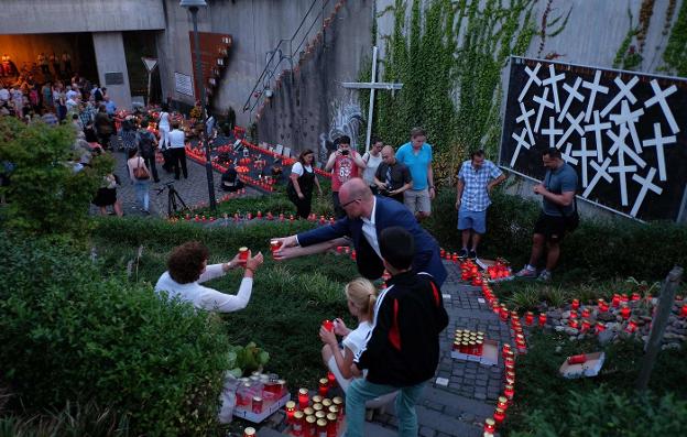 Un grupo de personas enciende velas y homenajea a las víctimas. :: pATRIK STOLLARZ / afp/