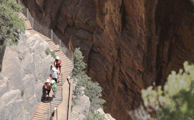 Turistas recorren la pasarela suspendida sobre el desfiladero de los Gaitanes, un cañón excavado por el río Guadalhorce. /J.M. Álvarez