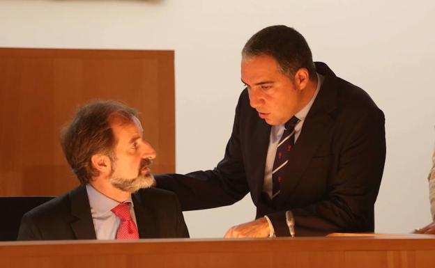 Bendodo, de pie, charla con Sichar en una sesión del pleno provincial. /Sur