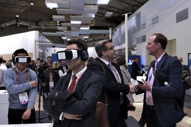Varios asistentes al último congreso mundial de telefonía (MWC) prueban el uso de gafas de realidad virtual para su trabajo. /Martín Benet