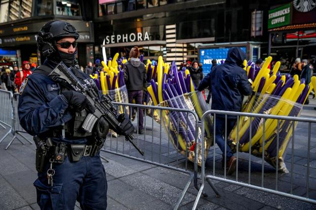 Un miembro de la unidad antiterrorista de la Policía de Nueva York vigila la preparación de los actos en Times Square. :: reuters/