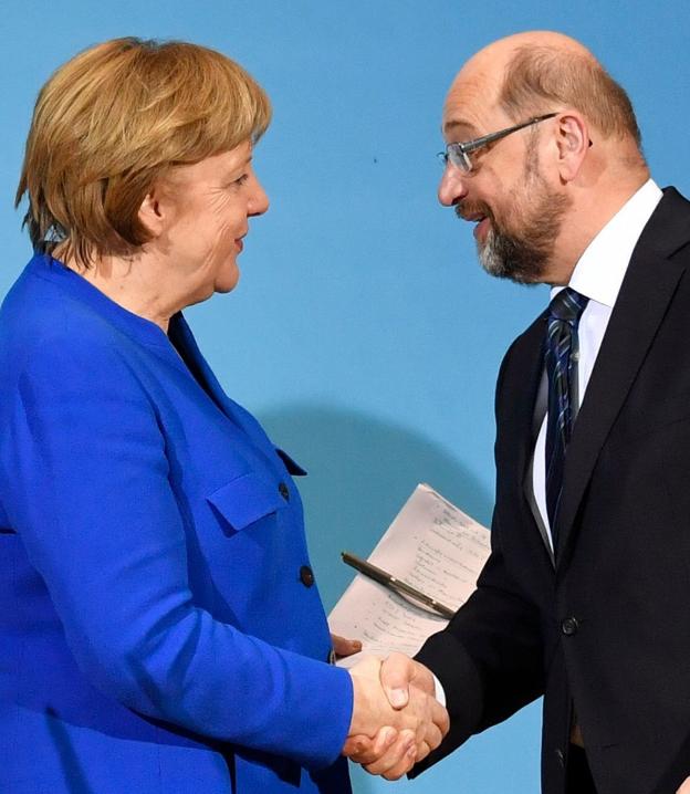 Merkel y Schulz sellan su acuerdo con un apretón de manos ante las cámaras. :: John MACDOUGALL / afp/