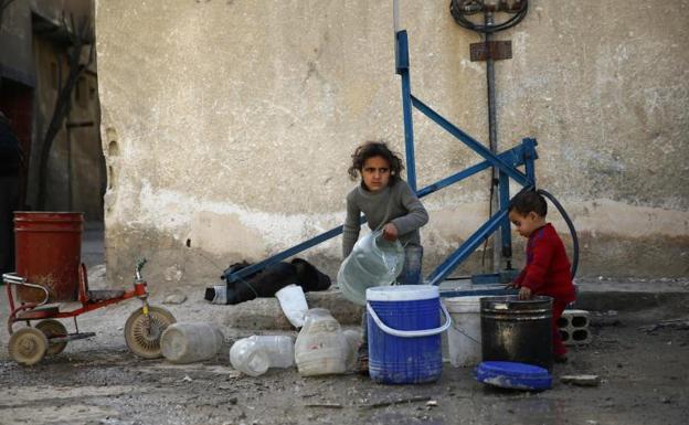 Niños recogen agua en Damasco./Reuters
