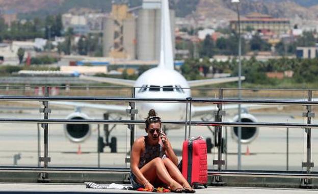 Una pasajera descansa, junto a su equipaje de mano, en la T3 mientras espera el vuelo con el que despide sus vacaciones en la Costa del Sol (archivo)./Salvador Salas