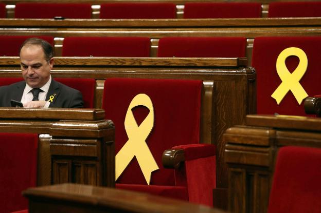 Turull, junto a los lazos amarillos en los escaños de Sànchez y Junqueras en el Parlament. :: t. albir / efe/