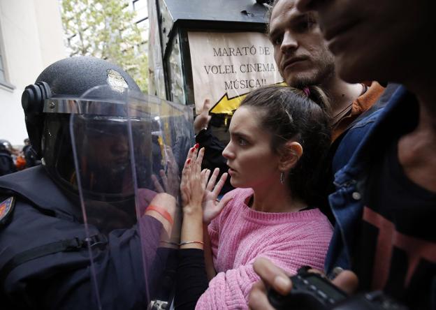Un policía se enfrenta el 1 de octubre a unos votantes en el referéndum ilegal. :: PAU BARRENA / afp/
