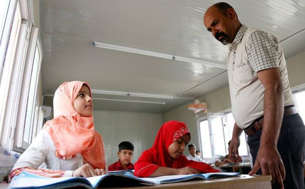 Malak (i) atiende a una clase. /Haidar HAMDANI (Afp)