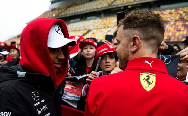 Lewis Hamilton charla con Sebastian Vettel, ante seguidores chinos./Afp
