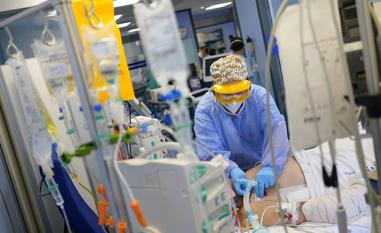 Una sanitaria atiende a un paciente de covid en una unidad de cuidados intensivos (UCI)./R. C.