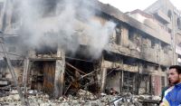 DEFLAGRACIÓN. Una nube de humo sale de un edificio tras la explosión registrada ayer en un mercado. / ALI ABBAS. EFE/
