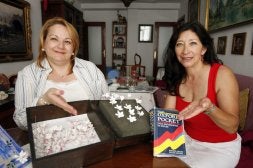 Rosa Maese, a la izquierda, muestra una de sus habilidades, y Carmen Elena Brown señala un diccionario de inglés. Son las dos primeras 'clientas' del banco. / CARLOS MORET/