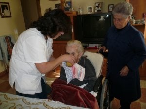 Una asistente social ayuda a una anciana en su domicilio. ::
M. V. COBOS/