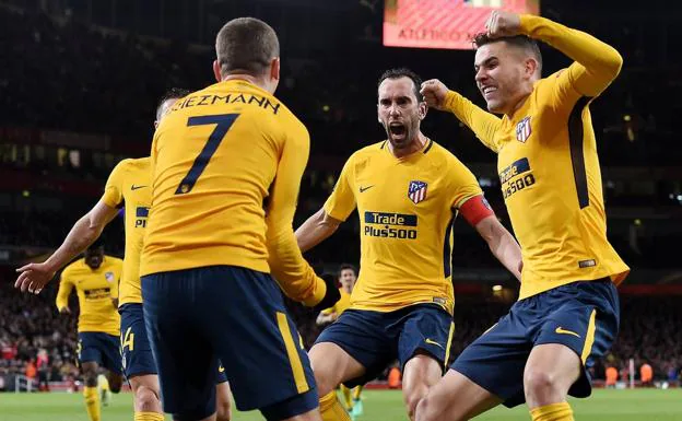 Godín y Lucas se abrazan a Griezmann tras marcar al Arsenal.
