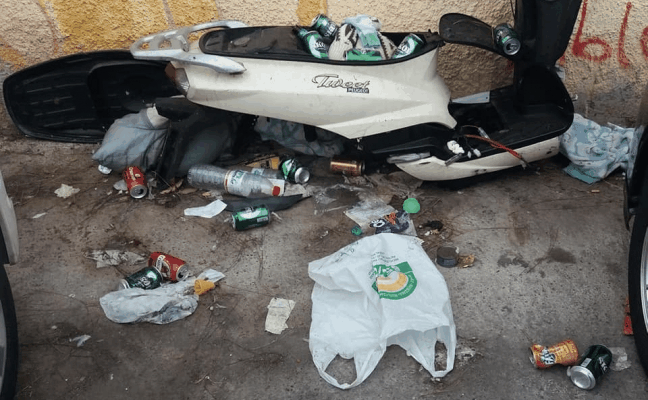 Restos de un ciclomotor entre latas de cerveza, botellas vacías y bolsas de plástico./SUR