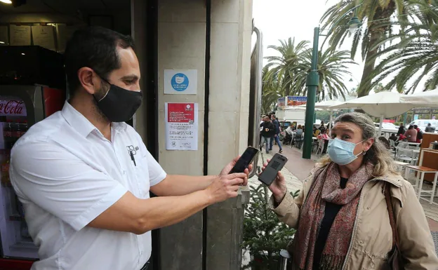 Un camarero comprueba que un cliente tenga el pasaporte Covid para poder entrar al interior del local. 