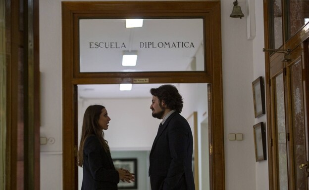 Carmen, de 26 años, y Guillermo, de 23, dos de los 35 diplomáticos de la última promoción, charlan en el pasillo de entrada de la Escuela Diplomática, en Madrid. /virginia carrasco